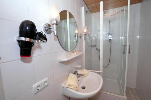 a white bathroom with a sink and a shower at Landhaus in Balderschwang