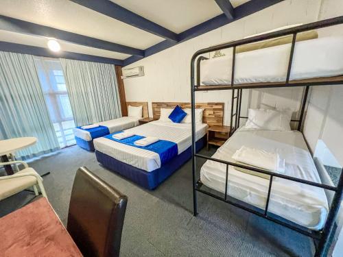 Snow Season Motor Inn في كوما: غرفة بسريرين بطابقين وطاولة