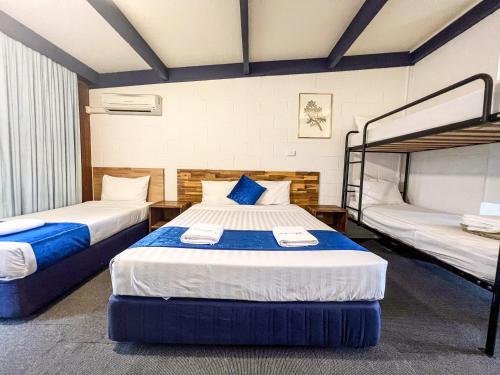 two beds in a room with two bunk beds at Snow Season Motor Inn in Cooma