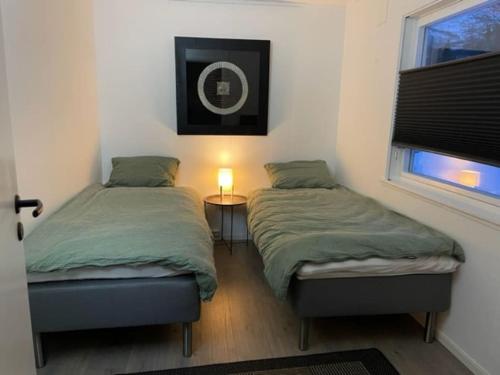a bedroom with two beds and a window and a lamp at House with garage in central Lyngen in Lyngseidet