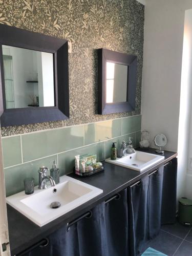 une salle de bain avec deux lavabos et deux miroirs dans l'établissement Maison du 7, à Saint-Ouen-en-Belin