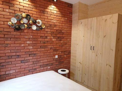 a brick wall in a room with a bed and a brick wall at Les Iris Véranda Parcking in Le Mont-Dore