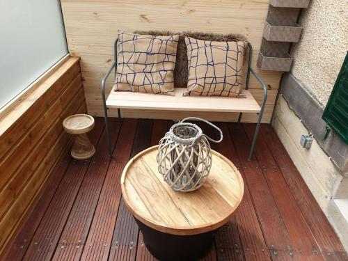 a vase sitting on a wooden table on a porch at Les Iris Véranda Parcking in Le Mont-Dore