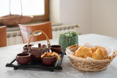 a table with a basket of bread and a tea pot at Apartment Ajdi in Ajdovščina