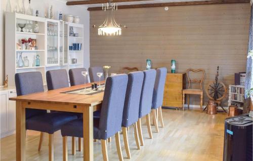 comedor con mesa de madera y sillas azules en Gorgeous Home In Visby With Sauna, en Visby