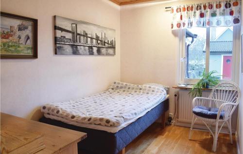 ヴィスビーにあるAmazing Home In Visby With 4 Bedrooms And Saunaのベッドルーム1室(ベッド1台、椅子2脚、窓付)