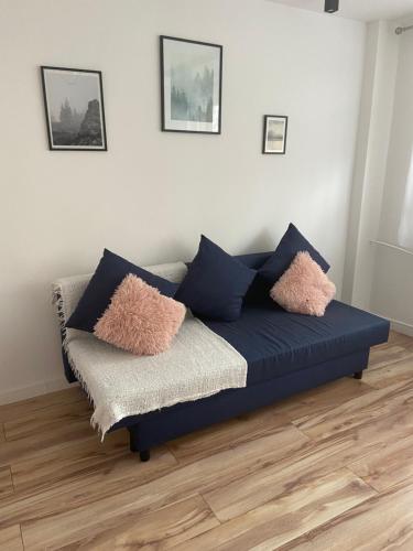 a blue couch in a living room with pillows on it at Apartament w centrum miasta in Suwałki