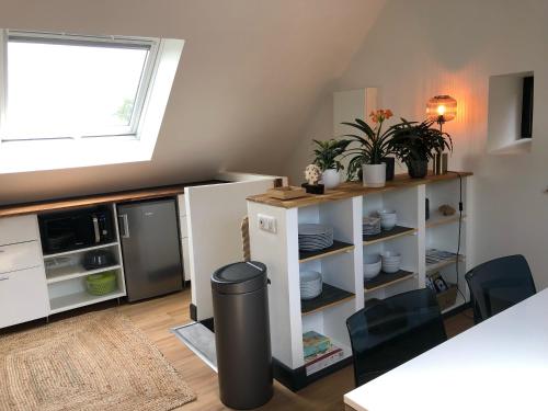 - une cuisine équipée d'un réfrigérateur et d'une table avec une poubelle dans l'établissement Sur les hauteurs de Locronan, à Locronan