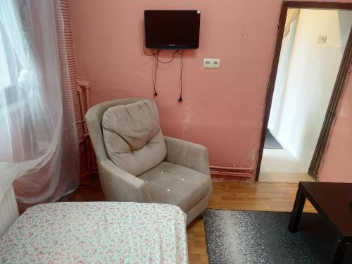sala de estar con silla y TV en la pared en Ceylan Köşk Apartman, en Estambul