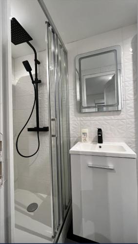 une salle de bain avec une douche, un lavabo et un miroir dans l'établissement Bella vita - Studio tout équipé - Tv Netflix - centre ville 100m- Gare 50m - Basilique 200m, à Lisieux
