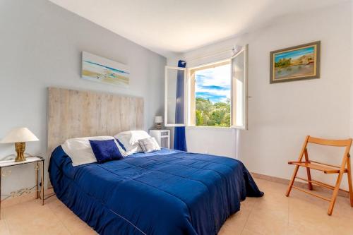 une chambre avec un lit bleu et une fenêtre dans l'établissement Villa for 9 people 15 mins walk from the beaches and the center of Ste Maxime, à Sainte-Maxime