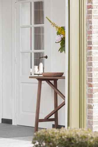 a table next to a door with a bowl on it at De Pastorie Diksmuide in Diksmuide