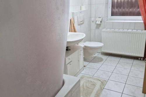 a white bathroom with a toilet and a sink at Einliegerwohnung mit Küche in Bischweier