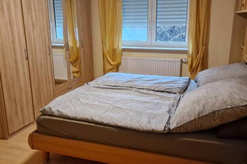 a small bed in a room with a window at Einliegerwohnung mit Küche in Bischweier