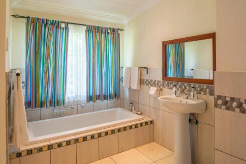 uma casa de banho com uma banheira e um lavatório em Batonka Guest Lodge em Victoria Falls