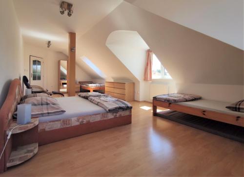 a attic bedroom with two beds and a staircase at Vila Plana nad Luznici in Planá nad Lužnicí