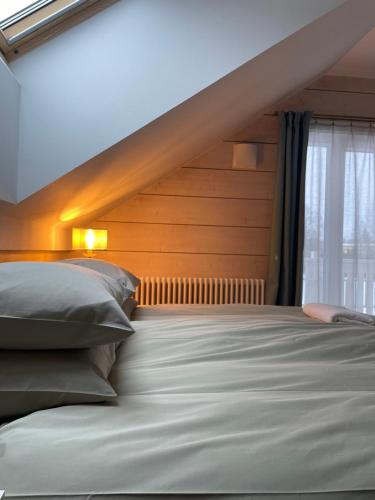 Schlafzimmer mit einem Bett mit einem Kopfteil aus Holz und einem Fenster in der Unterkunft Karukella puhkemaja in Lüganuse