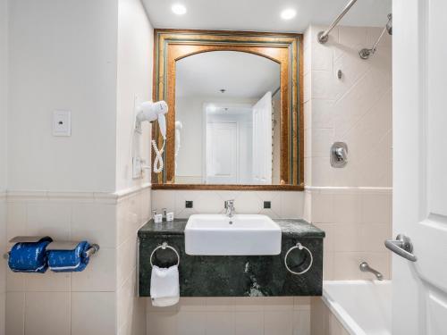 a bathroom with a sink and a mirror at LEGENDS HOTEL - hosted by Coastal Letting in Gold Coast