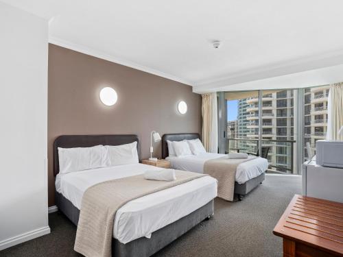 a hotel room with two beds and a balcony at LEGENDS HOTEL - hosted by Coastal Letting in Gold Coast