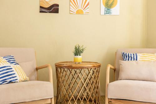 a living room with two chairs and a table with a plant on it at Indie Beach Bungalows in Ko Chang