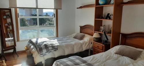 a bedroom with two beds and a window at O MEU LAR in Roxos