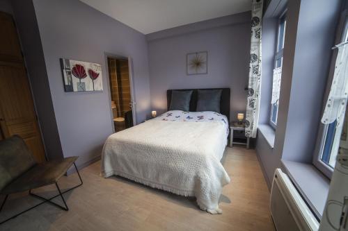 ベルグにあるGite Bergues Centreの紫色の部屋に白いベッドが備わるベッドルーム1室