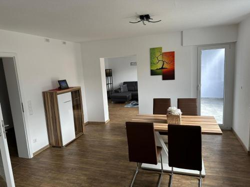 sala de estar con mesa de madera y sillas en Casa Ideal, en Bruchsal