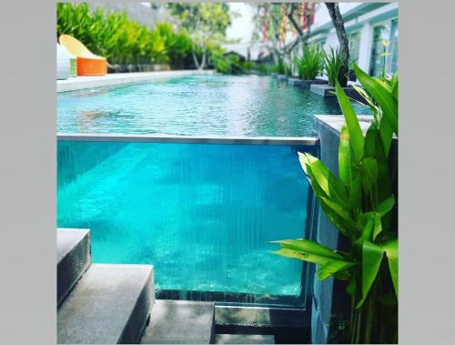 una piscina in una casa con acqua blu di Zuri Express Jimbaran a Jimbaran