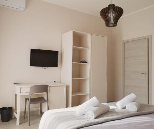 1 dormitorio con 1 cama, escritorio y TV en Il Balcone di Galatea, en Acireale