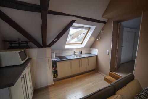 an attic kitchen with a sink and a window at Gite Bergues Centre in Bergues