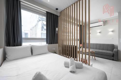 ein Schlafzimmer mit einem weißen Bett und einem Sofa in der Unterkunft Bonsai, Nilie Hospitality MGMT in Thessaloniki