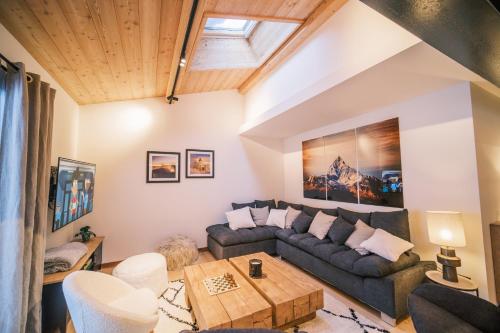 un salon avec un canapé et une table dans l'établissement Loft Zodiak -Centre Ville , 5 Chambres+ Vue, aux Houches