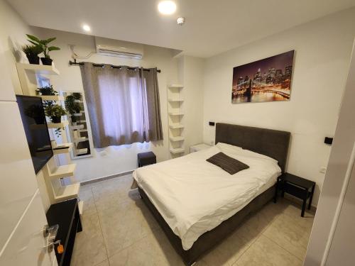 a small bedroom with a bed and a window at The boutique in Jerusalem