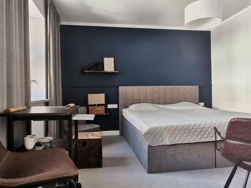 a bedroom with a bed with a blue wall at Motyl Noclegi Bytom in Bytom