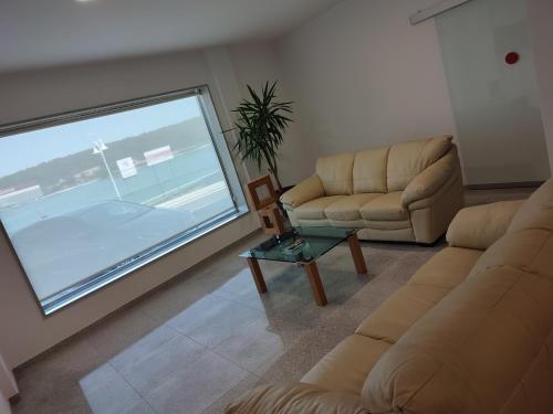 a living room with two couches and a large window at Hotel Brisa del Mar in O Grove