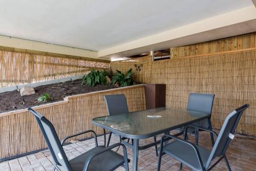a patio with a table and four chairs at Family Fun Oasis Pool Retreat Near Theme Parks in Gold Coast