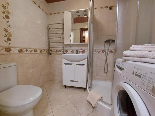 een badkamer met een wastafel en een wasmachine bij Затишна студія біля центру in Loetsk