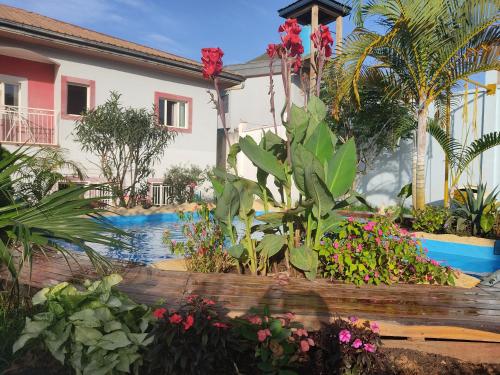 einen Garten vor einem Haus mit Blumen in der Unterkunft Residence Jardin Tropical in Jaunde