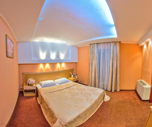 a hotel room with a bed and a blue ceiling at Optima Deluxe Kryvyi Rih in Kryvyi Rih