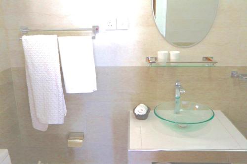 a bathroom with a sink and a mirror and towels at Mango Tree House in Beruwala