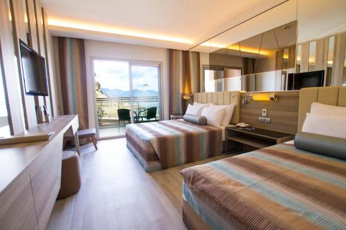 a hotel room with two beds and a balcony at Turunc Premium Hotel in Turunç