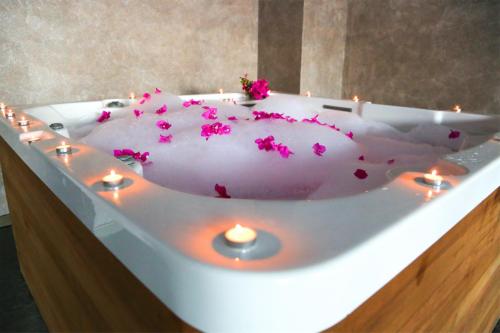 a white bath tub with pink flowers on it at Turunc Premium Hotel in Turunç