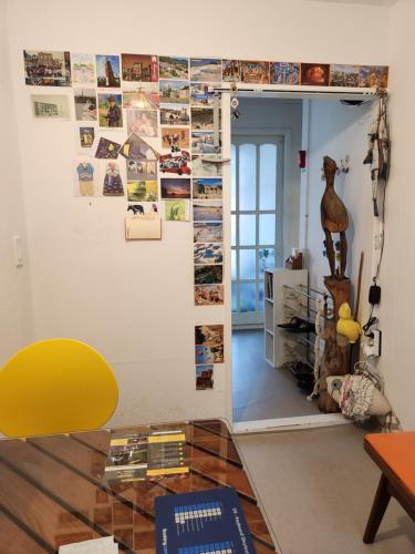 uma sala de estar com uma cadeira amarela e uma parede com fotografias em Aark House em Gangneung