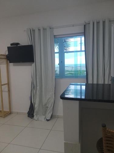 a kitchen with a large window and a counter top at pousada beira mar suites São Bento in Maragogi