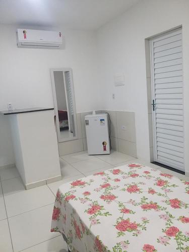Habitación blanca con cama y nevera. en pousada beira mar suites São Bento en Maragogi