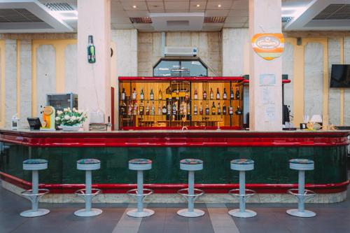 a bar with stools in a room with alcohol bottles at Motel Piatra Corbului in Bicaz