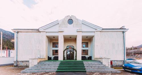 a white church with stairs leading to the door at Motel Piatra Corbului in Bicaz