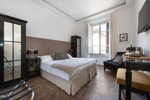 een slaapkamer met een bed, een bank en een bureau bij RFC Repubblica Florence Core B&B in Florence