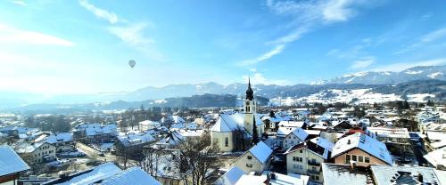 a city with snow covered roofs and a church at Sanosueno 2 in Sonthofen