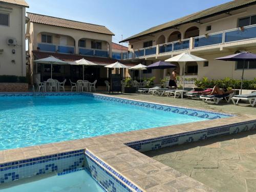 a swimming pool in front of a hotel at TRANQUIL RESORT HOTEL in Brusubi